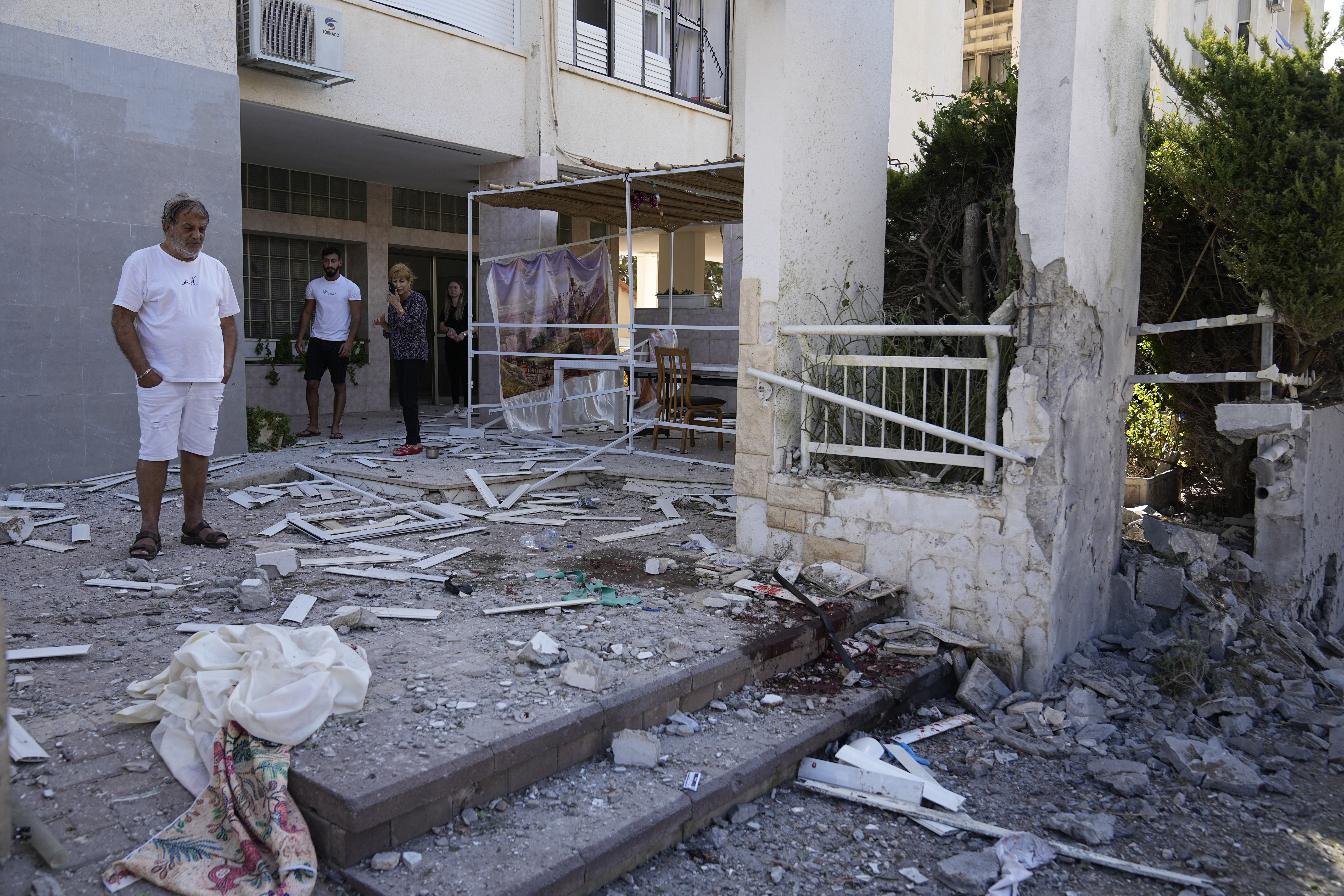 Residents look at damage after a rocket attack from the Gaza Strip in Ashkelon, Israel, on Saturday, Oct. 7, 2023.