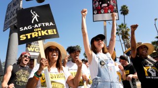 Striking actors Jennifer Leigh Warren, left, and Emily Kincaid, right, demonstrate outside Netflix studios, Tuesday, Oct. 17, 2023, in Los Angeles. (AP Photo/Chris Pizzello)