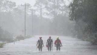 Rescue workers with Tidewater Disaster Response wade through a tidal surge on a highway while looking for people in need of help after the Steinhatchee River flooded on, Aug 30, 2023, in Steinhatchee, Fla., following the arrival of Hurricane Idalia. (Douglas R. Clifford/Tampa Bay Times via AP, File)