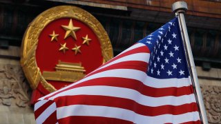 An American flag is flown next to the Chinese national emblem