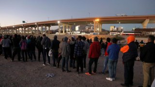 File -Venezuelan migrants stand in front of the US Border Patrol operations post across the Rio Grande, in Ciudad Juarez, state of Chihuahua, Mexico, on Oct. 25, 2022.