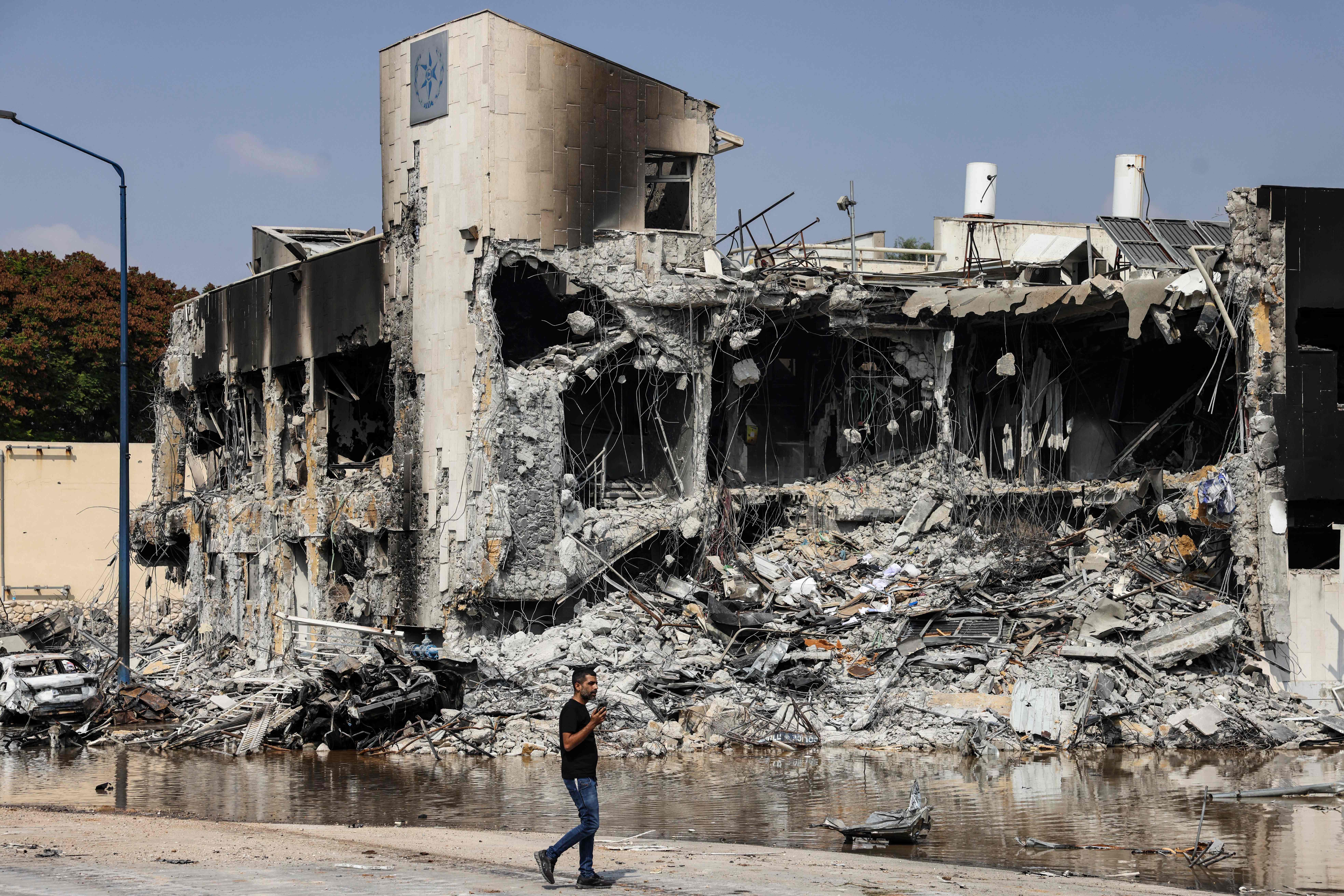 A man walks past an Israeli police station in Sderot after it was damaged during battles to dislodge Hamas militants who were stationed inside, on Oct. 8, 2023.