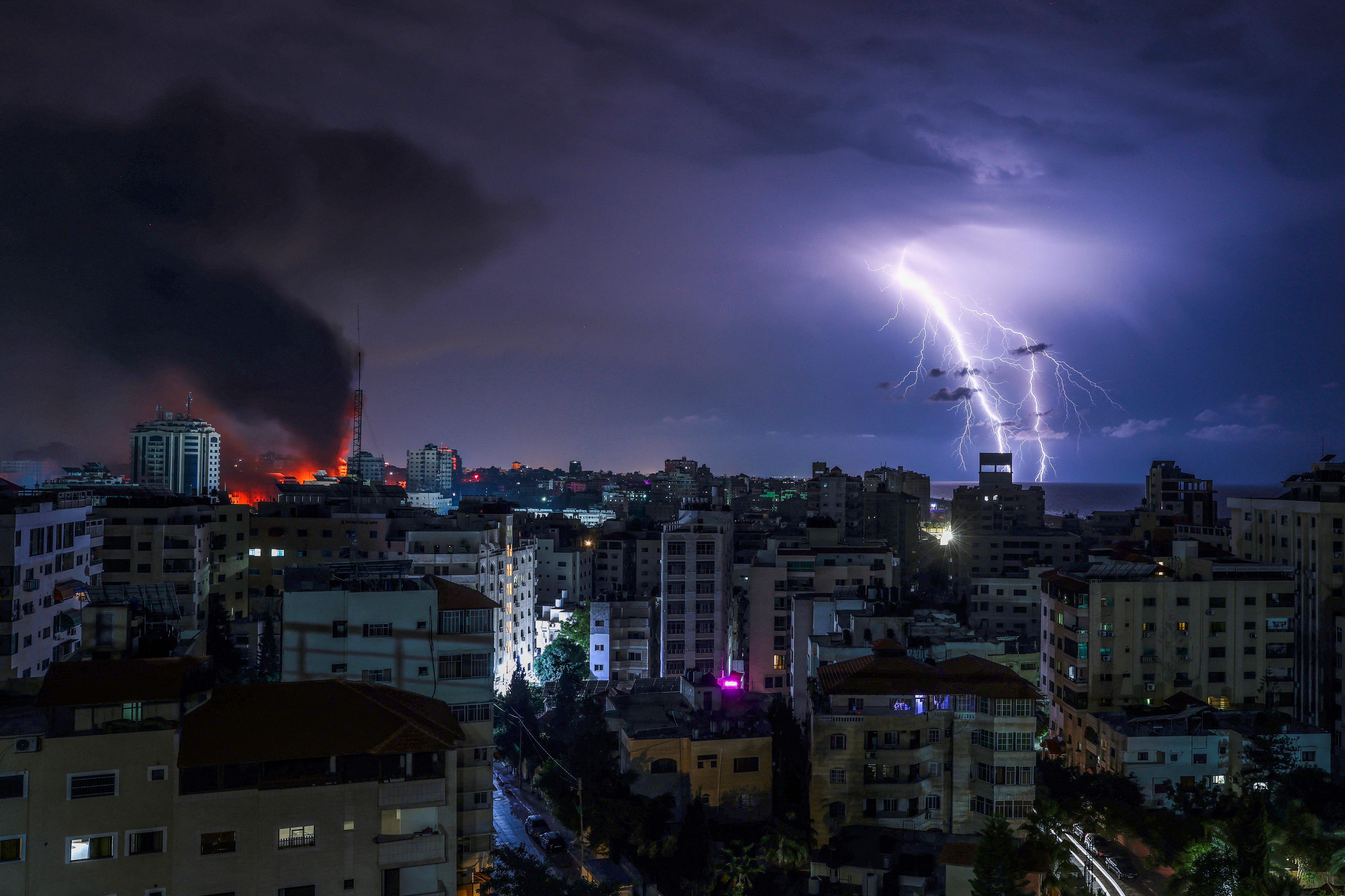 Lightning strikes as smoke billows following an Israeli airstrike in Gaza City on Oct. 9, 2023.