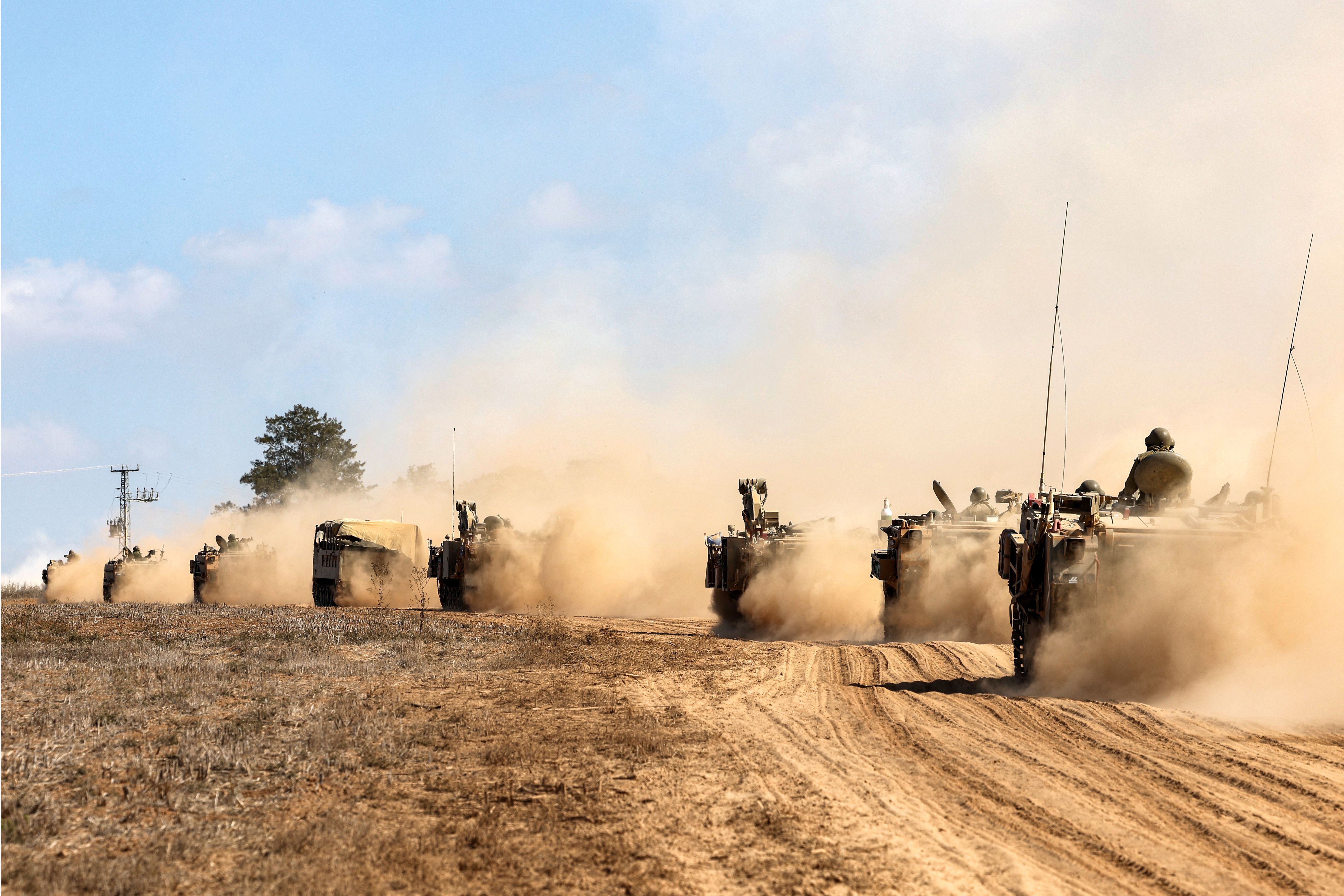 Israeli army tanks and vehicles deploy along the border with the Gaza Strip in southern Israel on Oct. 13, 2023.