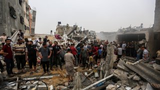 KHAN YUNIS, GAZA – OCTOBER 29: People search through buildings that were destroyed during Israeli air raids in the southern Gaza Strip on October 29, 2023 in Khan Yunis, Gaza. Heading into a third week of heavy bombing from Israel, Gaza buckles under a shortage of basic needs including fuel, whilst several neighborhoods on the Gaza strip have been wiped out and thousands have died and hundreds of thousands have been displaced. On October 7, Hamas launched a deadly attack in southern Israel that sparked a retaliatory siege of Gaza. (Photo by Ahmad Hasaballah/Getty Images)