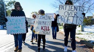 A small number of employees and supporters picket outside the headquarters of drugstore chain Walgreens during a three-day walkout by pharmacists in Deerfield, Illinois, November 1, 2023.