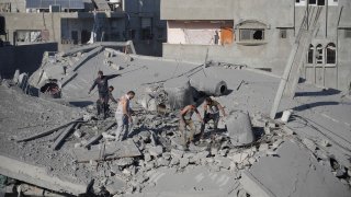 Palestinians look for survivors after an Israeli strike in the Nusseirat refugee camp in the Gaza Strip on Saturday, Nov. 4, 2023.