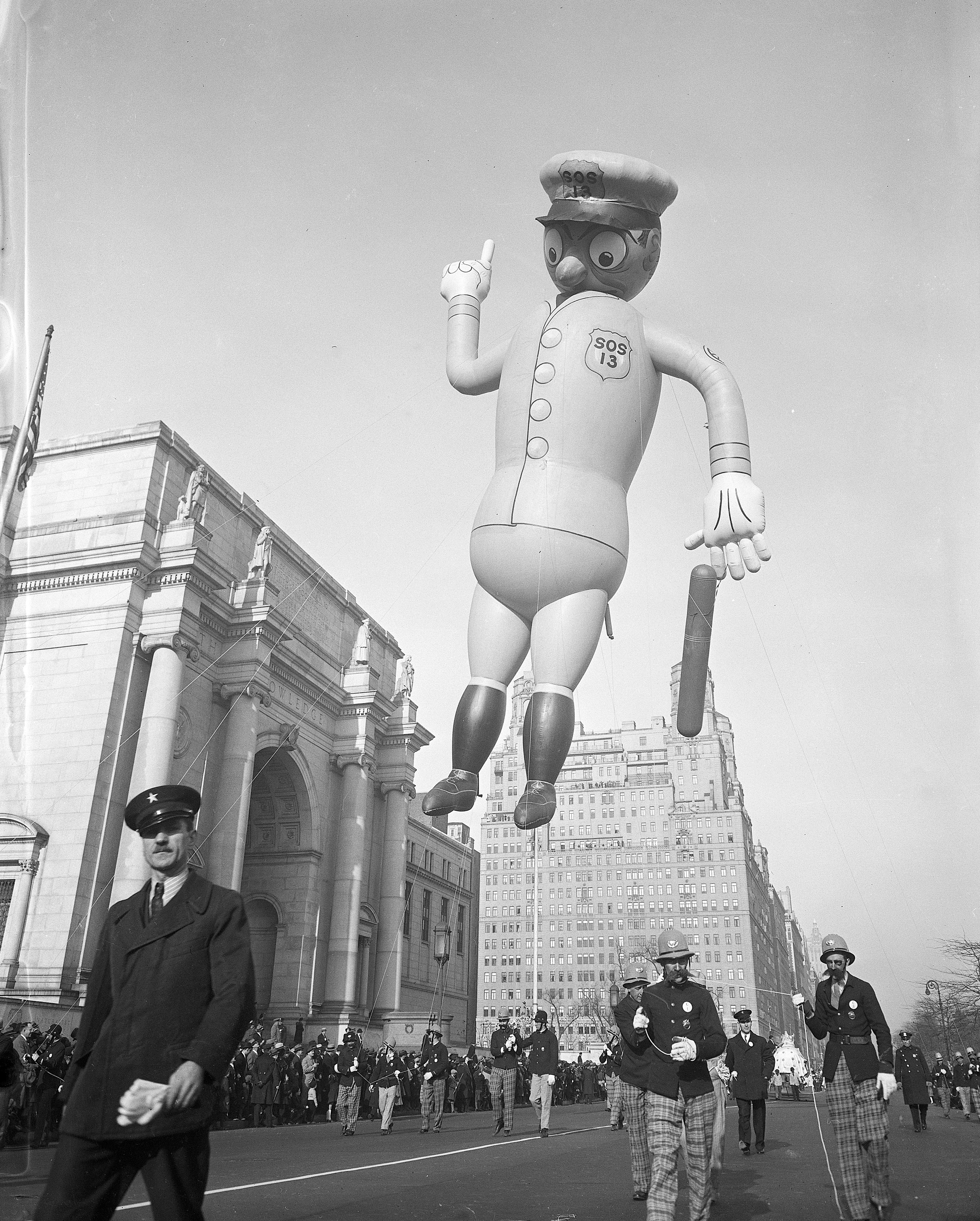 A parade balloon in the shape of a New York City cop is led down the street during the annual Macy’s Thanksgiving Day Parade.