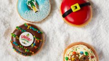 Four Elf-themed Krispy Kreme donuts on a bed of snow.