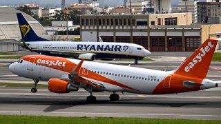 LISBON, PORTUGAL – APRIL 01: An easyJet aircraft moves past
a Ryanair airplane while taking off for London at Humberto Delgado International Airport during the first of a three-day strike by the low cost carrier cabin crew on April 01, 2023 in Lisbon, Portugal. EasyJet cabin crew strike in Portugal, called by the National Civil Aviation Flight Personnel Union (SNPVAC), takes place from April 01 to 03. The Portuguese Ministry of Infrastructure and the Ministry of Labor ordered that there have be a minimum service of 52 easyJet flights during the workers’ strike, deemed necessary to meet social needs relating to the constitutional right to travel, taking into account the season covered by the declared strike days, on which is expected the displacement of a significant number of people. (Photo by Horacio Villalobos#Corbis/Getty Images)