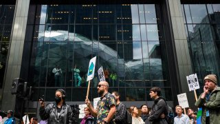 The Amazon Spheres are reflected in windows as Amazon employees and supporters gather during a walk-out protest against recent layoffs, a return-to-office mandate, and the company’s environmental impact, outside Amazon headquarters in Seattle, Washington, on May 31, 2023.