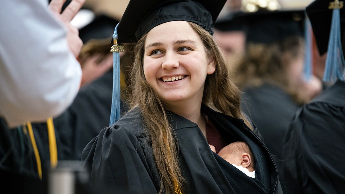 Michigan girl receives diploma with new child child tucked inside graduation gown