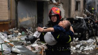 A firefighter carries a man from a damaged residential building after a Russian missile strike, in Kyiv, Ukraine, Tuesday, Jan. 2, 2024.