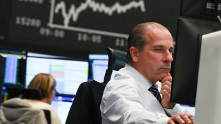 A stock trader looks at his monitors in the trading room of the Frankfurt Stock Exchange. Worries about a new coronavirus mutation in southern Africa have dealt a major blow to the German stock market.
