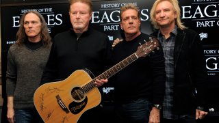 FILE – Members of The Eagles, from left, Timothy B. Schmit, Don Henley, Glenn Frey and Joe Walsh pose with an autographed guitar after a news conference at the Sundance Film Festival, Jan. 19, 2013, in Park City, Utah.