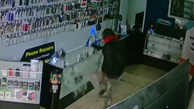 Surveillance shows burglar using shopping cart to break into cellphone store