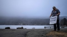 Town Clerk Sandra Lacasse, places a sign outside the town office as polls opens Tuesday, March 5, 2024, in Elmore, Vt. Super Tuesday elections are being held in 16 states and one territory. Hundreds of delegates are at stake, the biggest haul for either party on a single day. (AP Photo/David Goldman)