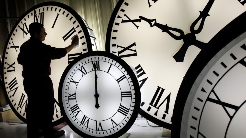 Electric Time Co. employee Walter Rodriguez cleans the face of an 84-inch Wegman clock.