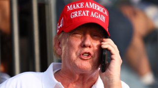 Former U.S. President Donald Trump speaks on the phone at the 18th green during day three of the LIV Golf Invitational – Miami at Trump National Doral Miami on April 07, 2024 in Doral, Florida. 