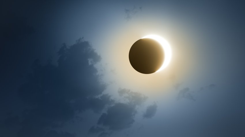 Solar Eclipse with dark blue sky and clouds