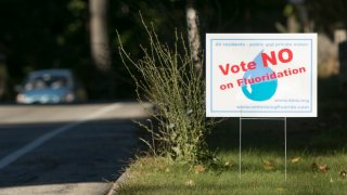 File – Signs have sprung up on roadsides urging a no vote on a referendum asking residents in seven towns served by the Kennebunk, Kennebunkport and Wells Water District in Maine if they want to continue adding fluoride to drinking water.