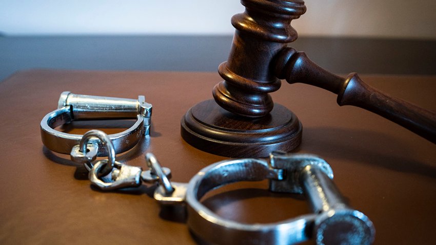 Gavel and handcuffs on a leather surface