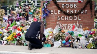 FILE - Reggie Daniels pays his respects a memorial at Robb Elementary School, Thursday, June 9, 2022, in Uvalde, Texas.
