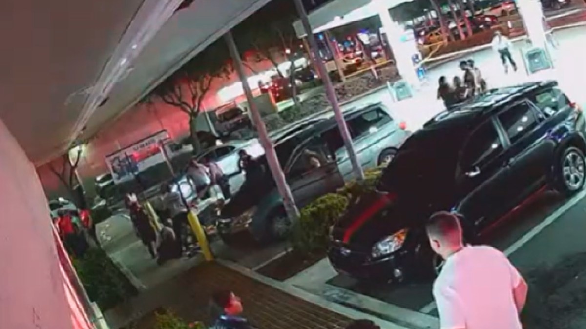 Surveillance video shows one of the victims sitting in front of the McDonald's, as police and paramedics rush over to help.
