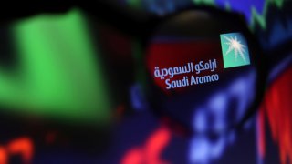 Saudi Aramco logo and stock graph are seen through a magnifier displayed in this illustration taken September 4, 2022. 