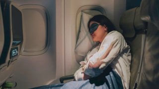 Woman sleeping on a plane.