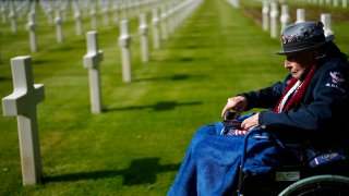 World War II and D-Day veteran Jake Larson visits the grave of a soldier from his unit at the Normandy American Cemetery in Colleville-sur-Mer, France, Tuesday, June 4, 2024. World War II veterans from across the United States as well as Britain and Canada are in Normandy this week to mark 80 years since the D-Day landings that helped lead to Hitler's defeat.