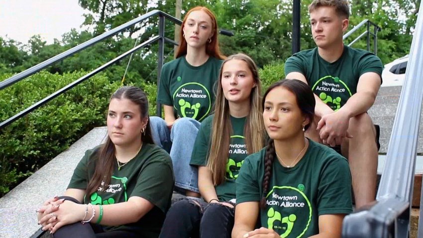 Five members of the Newtown High School graduating class sit on steps