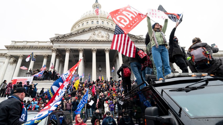 Trump supporters stand on the U.S. Capitol Police armored vehicle as others take over the steps of the Capitol on Wednesday, Jan. 6, 2021, as the Congress works to certify the electoral college votes.