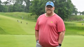 Paul Emerson, a fan, smiles for a photo after having caddied for C.T. Pan of Taiwan for a portion of the final round of the RBC Canadian Open