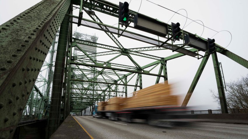 A logging truck drives on the Interstate 5 bridge