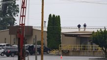 BUTLER, PENNSYLVANIA - JULY 14: Two FBI investigators scan the roof of AGR International Inc, the building adjacent to the Butler Fairgrounds, from which alleged shooter Matthew Thomas Crooks fired at former President Donald J. Trump, in the aftermath of the attempted assassination at a campaign rally on July 14, 2024 in Butler, Pennsylvania. Trump was escorted away by the Secret Service with an injury to his ear.  One attendee at the rally on July 13 was killed and two others severely injured. (Photo by Jeff Swensen/Getty Images)