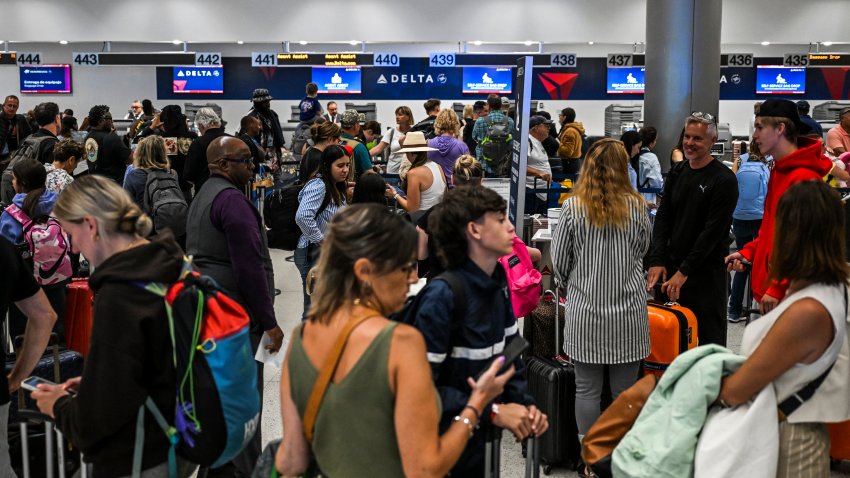 Passengers at Miami International Airport line up at check-in counters on July 19, 2024, in Miami, Florida, during a major worldwide computer systems outage. The outage has wrought havoc on computer systems worldwide, grounding flights across the globe, including in Europe and the US, derailing television broadcasts in the UK and impacting telecommunications in Australia. US carriers Delta and United Airlines grounded all their flights earlier on July 19 over communication issues, the Federal Aviation Administration said. (Photo by CHANDAN KHANNA / AFP) (Photo by CHANDAN KHANNA/AFP via Getty Images)