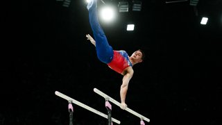 US’ Paul Juda competes in the parallel bars event of the artistic gymnastics men’s all-around final during the Paris 2024 Olympic Games at the Bercy Arena in Paris, on July 31, 2024. (Photo by Loic VENANCE / AFP) (Photo by LOIC VENANCE/AFP via Getty Images)