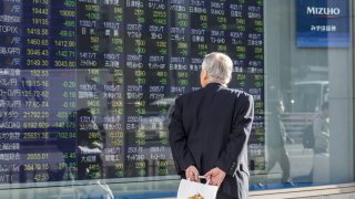 A pedestrian looks at an electronic stock board outside a securities firm in Tokyo, Japan, on Tuesday, Dec. 25, 2018.