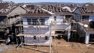 Construction workers work on a home, as a subdivision of home is built in San Marcos, California, January 31, 2023.