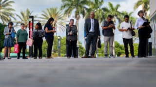 People line up as they wait for the JobNewsUSA.com South Florida Job Fair to open at the Amerant Bank Arena on June 26, 2024, in Sunrise, Florida.