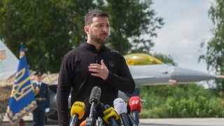 President of Ukraine Volodymyr Zelenskyi stands in front of the first General Dynamics F-16 Fighting Falcon received by Ukraine as he congratulates Ukrainian military on the Day of Ukrainian Air Force on August 4, 2024 in Unspecified, Ukraine.