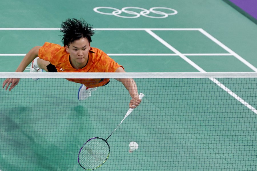 Japan's Yuta Watanabe dives for a shot in the mixed doubles badminton group stage match