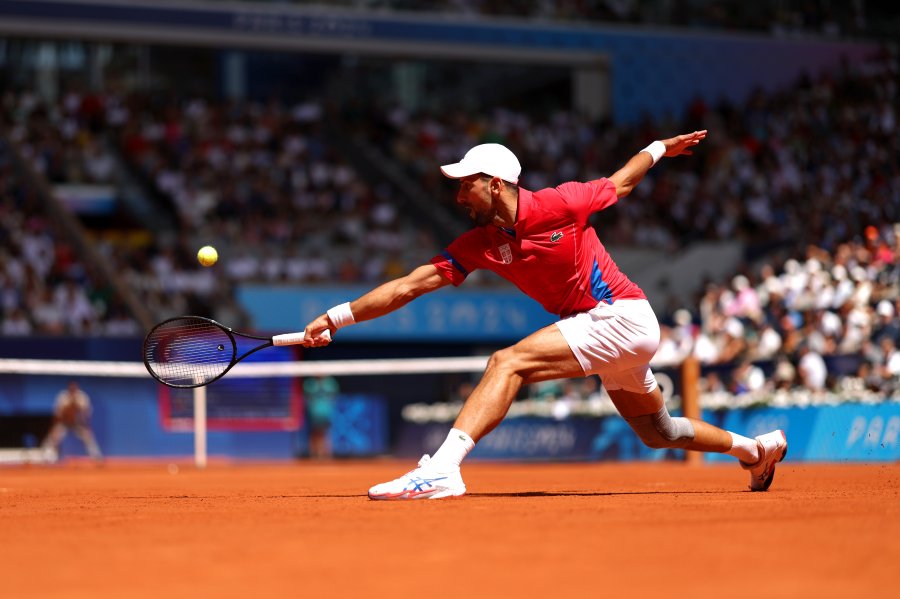 Novak Djokovic of Team Serbia plays a backhand during the Men's Singles Gold medal match against Carlos Alcaraz of Team Spain on day nine of the Olympic Games Paris 2024 at Roland Garros on August 04, 2024 in Paris, France