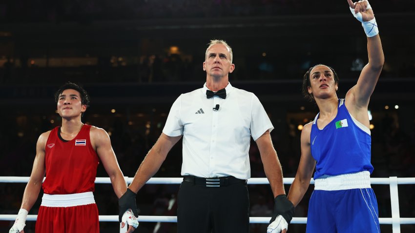 Janjaem Suwannapheng of Team Thailand looks on as Match Referee Shawn Reese raises the arm of Imane Khelif of Team Algeria to announce the winner of the Women's 66kg Semifinal round match on day eleven of the Olympic Games Paris 2024 at Roland Garros on August 06, 2024 in Paris, France.