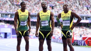 Jelani Walker, Kishane Thompson and Jehlani Gordon of Team Jamaica react following the Men's 4 x 100m Relay