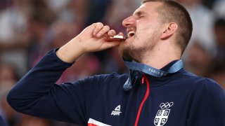 PARIS, FRANCE – AUGUST 10: Bronze medalist Nikola Jokic of Team Serbia bites his medal while posing for a photo on the podium during the Men’s basketball medal ceremony on day fifteen of the Olympic Games Paris 2024 at Bercy Arena on August 10, 2024 in Paris, France. (Photo by Ezra Shaw/Getty Images)