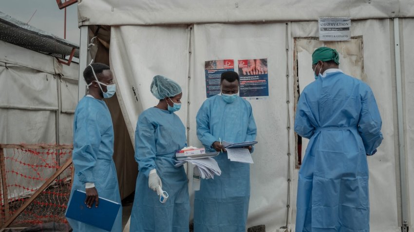 Health workers walk between wards at the Mpox treatment centre at Nyiragongo General Referral Hospital, north of Goma on August 17, 2024. With around 16,000 cases recorded since the beginning of the year, the DRC is the focus and epicentre of the epidemic that led the World Health Organisation (WHO) to trigger its highest level of alert at the international level on Wednesday. The province of South Kivu records around 350 new cases per week, according to Dr Justin Bengehya, epidemiologist at the provincial health division of South Kivu. Goma, capital of the province of North Kivu, almost surrounded by an armed rebellion and where hundreds of thousands of displaced people are crammed into makeshift camps, fears a large-scale spread due to promiscuity.