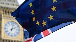 A photograph taken on January 31, 2024 shows a European Union flag and a Union Jack flag flapping in the air in front of the Elizabeth Tower, commonly known by the name of the clock’s bell “Big Ben”, at the Palace of Westminster, home to the Houses of Parliament, central London.