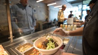 A customer selects dip and spread for his bowl at Cava.